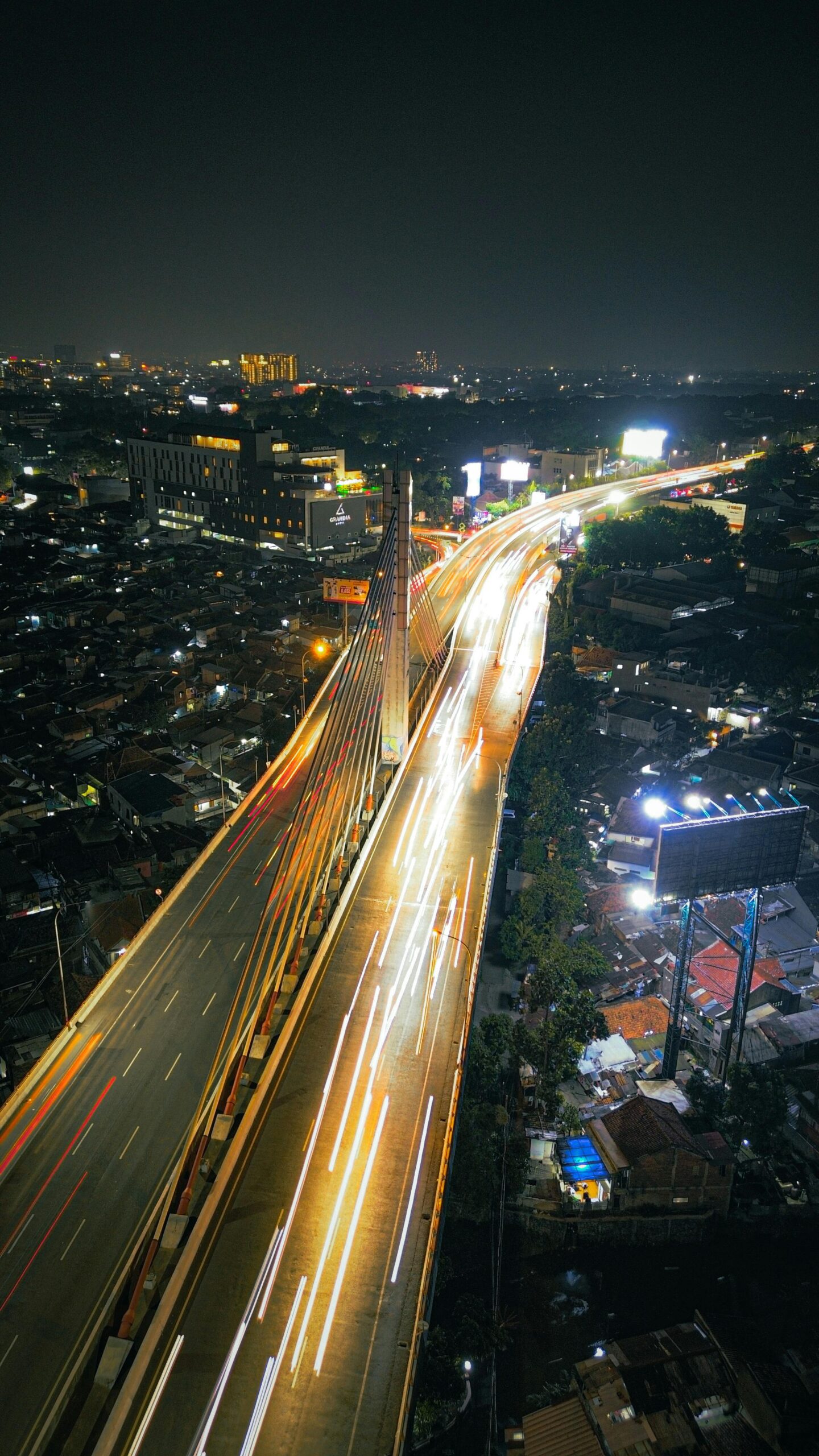 Stunning aerial view of illuminated highways and cityscape at night in Jawa Barat, Indonesia.
